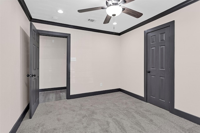 unfurnished bedroom with carpet floors, crown molding, visible vents, and baseboards