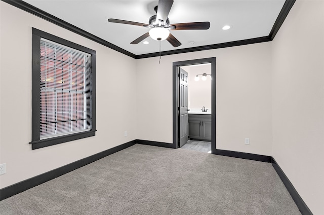 unfurnished bedroom featuring crown molding, light colored carpet, connected bathroom, and ceiling fan