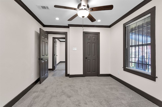 unfurnished bedroom featuring ornamental molding, ceiling fan, and light colored carpet