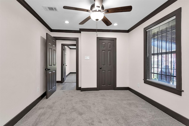 unfurnished bedroom featuring baseboards, crown molding, carpet flooring, and visible vents