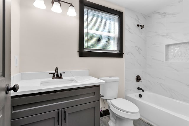 full bathroom with vanity, tiled shower / bath combo, and toilet