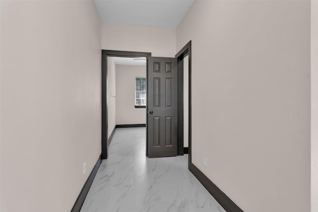 corridor featuring baseboards and marble finish floor