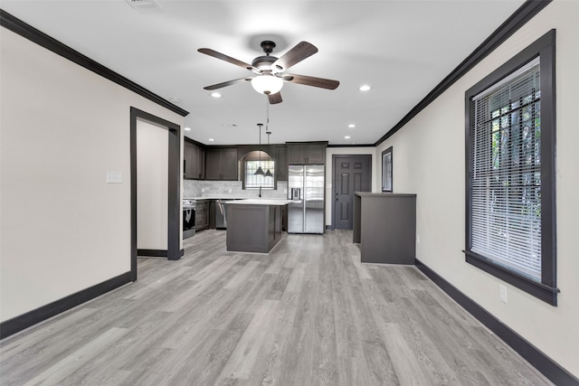 kitchen featuring a kitchen island, light hardwood / wood-style floors, crown molding, hanging light fixtures, and appliances with stainless steel finishes