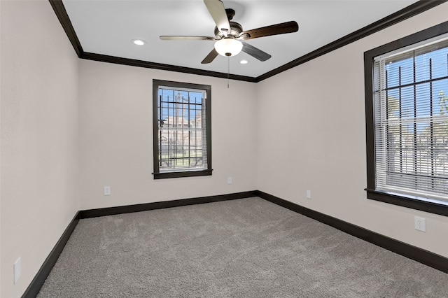 carpeted spare room with ceiling fan, ornamental molding, and a healthy amount of sunlight