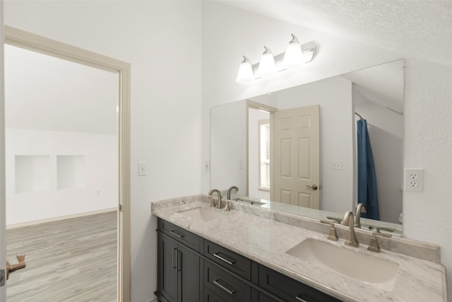 bathroom featuring vanity, a textured ceiling, hardwood / wood-style floors, and toilet