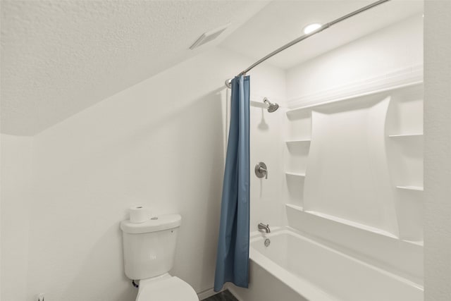 bathroom with shower / bath combination with curtain, a textured ceiling, and toilet