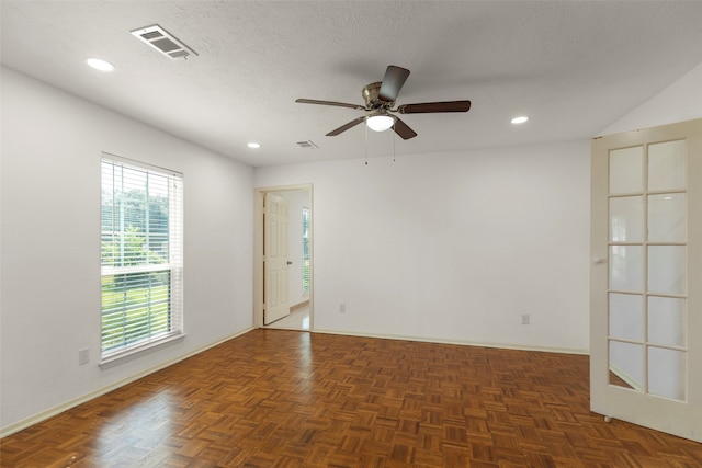 spare room featuring ceiling fan, a textured ceiling, and dark parquet floors