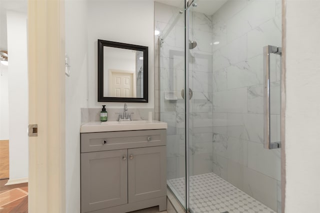 bathroom with walk in shower, vanity, and hardwood / wood-style flooring