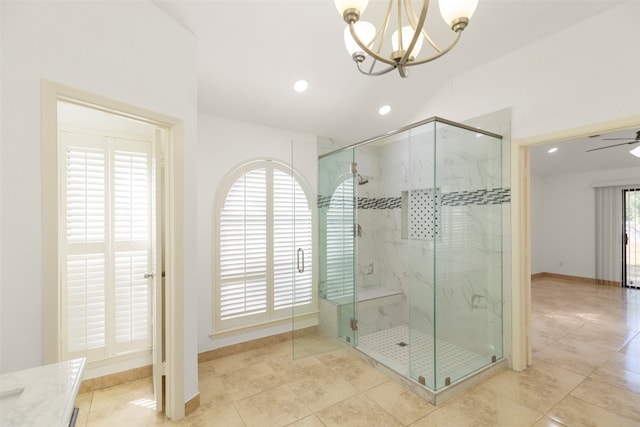 bathroom with ceiling fan with notable chandelier, plenty of natural light, and a shower with shower door