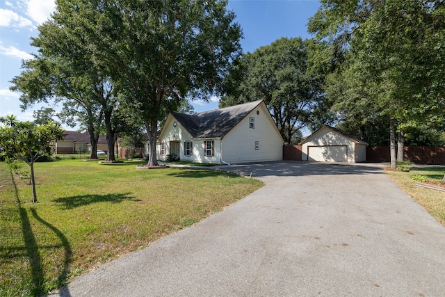 view of front of property featuring an outdoor structure, a garage, and a front lawn