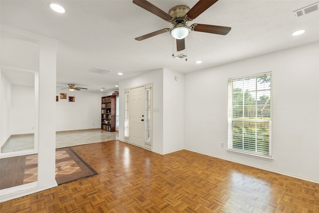 spare room featuring parquet floors, a textured ceiling, and ceiling fan