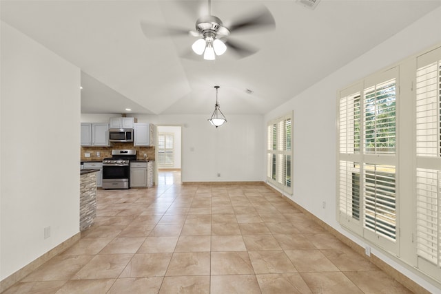 unfurnished living room with ceiling fan, light tile patterned floors, and vaulted ceiling