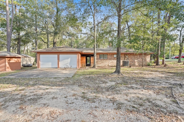 single story home featuring central air condition unit and a storage shed