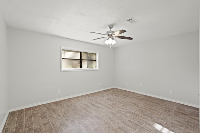 spare room with light wood-type flooring and ceiling fan