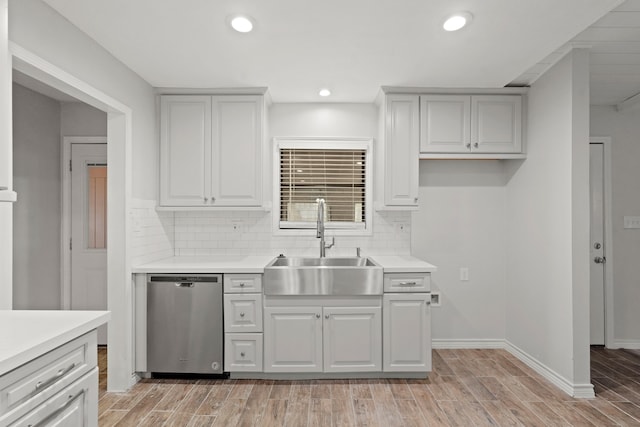 kitchen featuring light hardwood / wood-style flooring, stainless steel dishwasher, sink, and backsplash