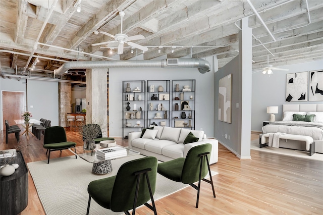 living room with visible vents, light wood-type flooring, a ceiling fan, and baseboards