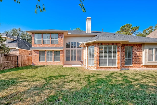 rear view of property with a lawn