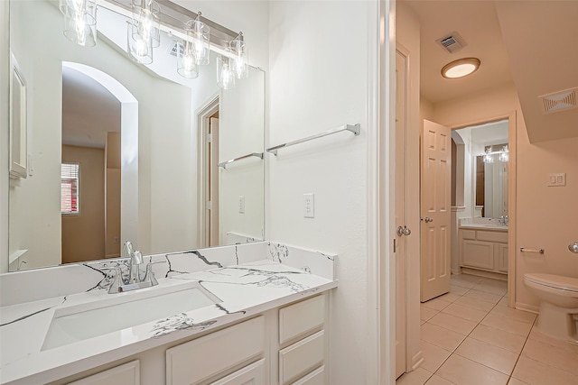 bathroom with tile patterned flooring, vanity, and toilet