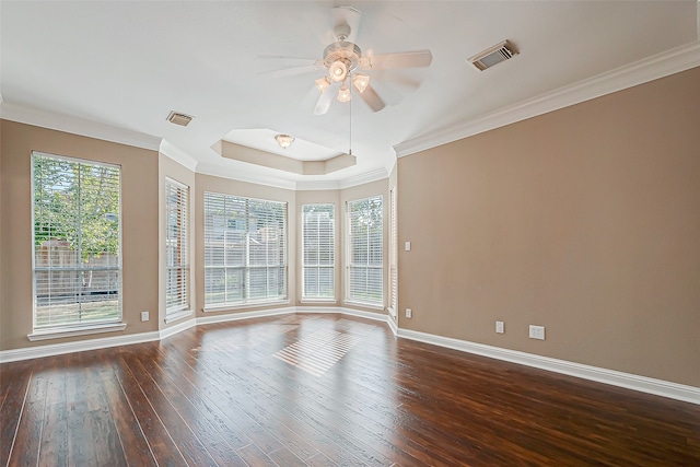 spare room featuring ceiling fan, dark hardwood / wood-style floors, ornamental molding, and a tray ceiling