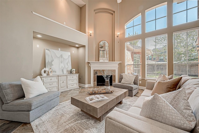 living room with a high ceiling and a tiled fireplace