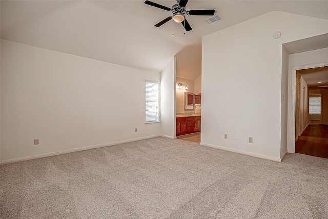 carpeted empty room featuring ceiling fan and vaulted ceiling