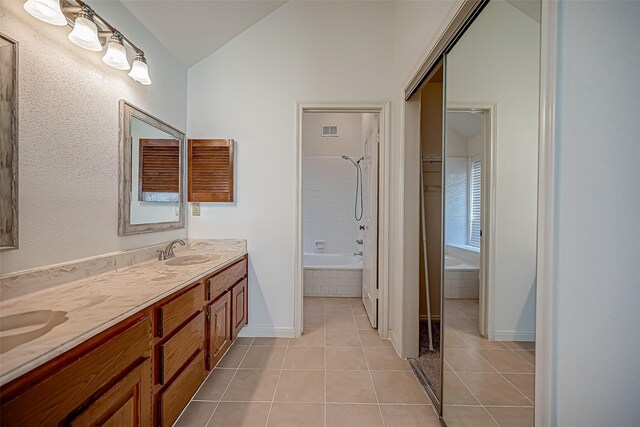 2810 Pineleaf Dr, Sugar Land, TX 77479 - full bath with tile patterned flooring, vaulted ceiling, double vanity, baseboards, and tiled shower / bath combo