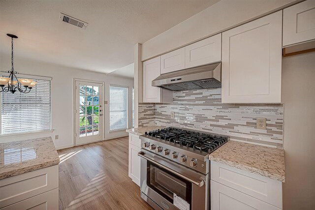 2810 Pineleaf Dr, Sugar Land, TX 77479 - kitchen with high end stainless steel range oven, under cabinet range hood, a chandelier, and white cabinets