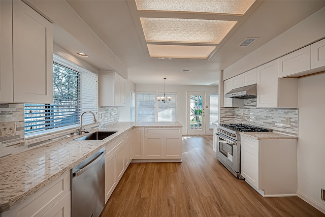 kitchen featuring pendant lighting, decorative backsplash, stainless steel appliances, and white cabinets