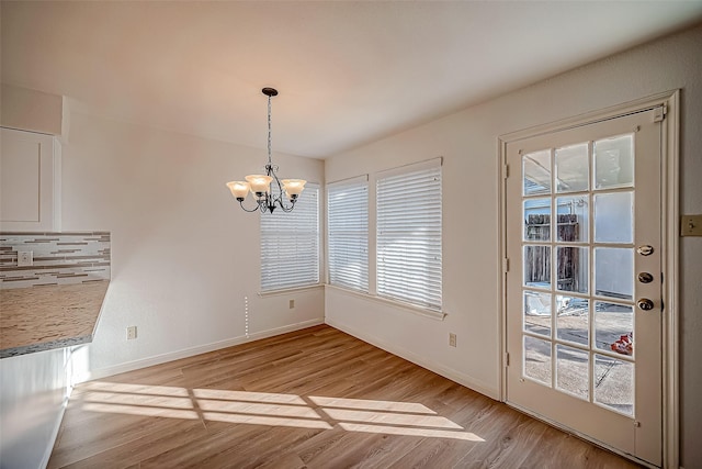 2810 Pineleaf Dr, Sugar Land, TX 77479 - unfurnished dining area featuring a chandelier, light wood-type flooring, and baseboards