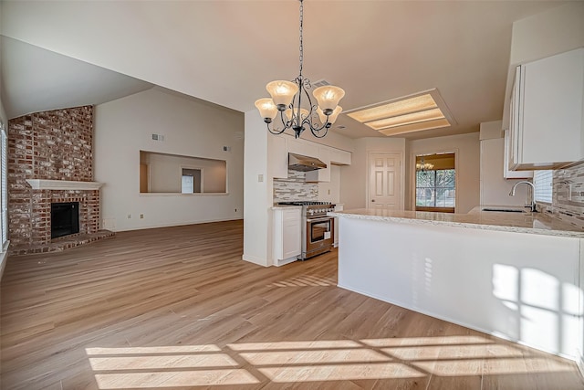 2810 Pineleaf Dr, Sugar Land, TX 77479 - kitchen with high end stainless steel range oven, a sink, a chandelier, white cabinetry, and lofted ceiling