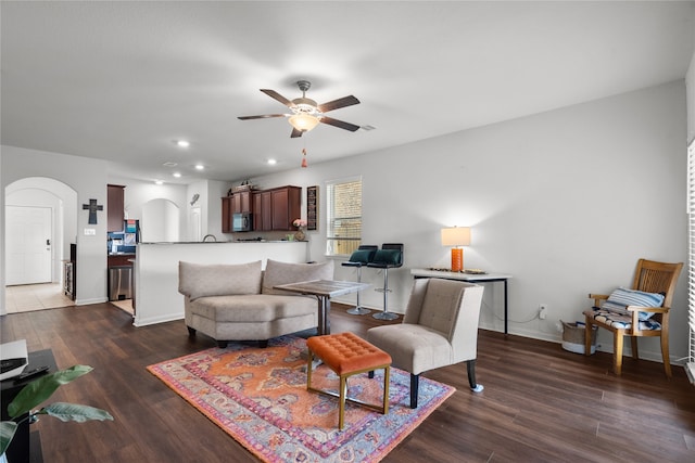 living room with ceiling fan and dark hardwood / wood-style floors