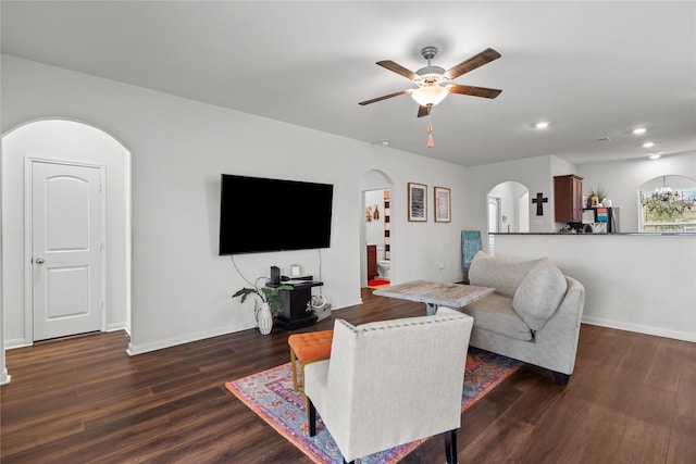 living room with ceiling fan and dark hardwood / wood-style flooring