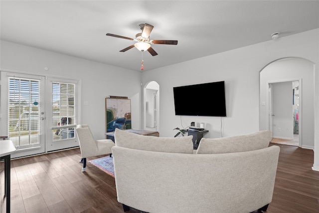 living room with ceiling fan and dark wood-type flooring