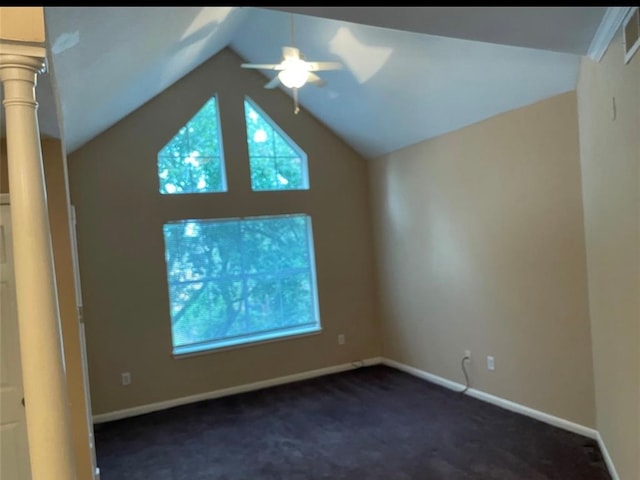 carpeted empty room with ornate columns, vaulted ceiling, and ceiling fan