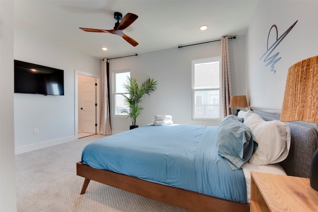 bedroom with ceiling fan, light carpet, and multiple windows