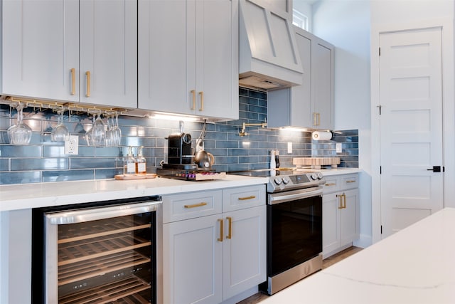 kitchen with wine cooler, backsplash, premium range hood, light stone countertops, and stainless steel electric range oven