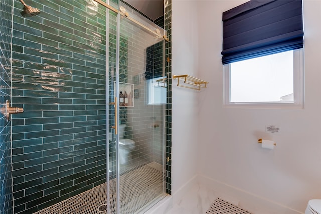 bathroom featuring a shower with shower door and toilet