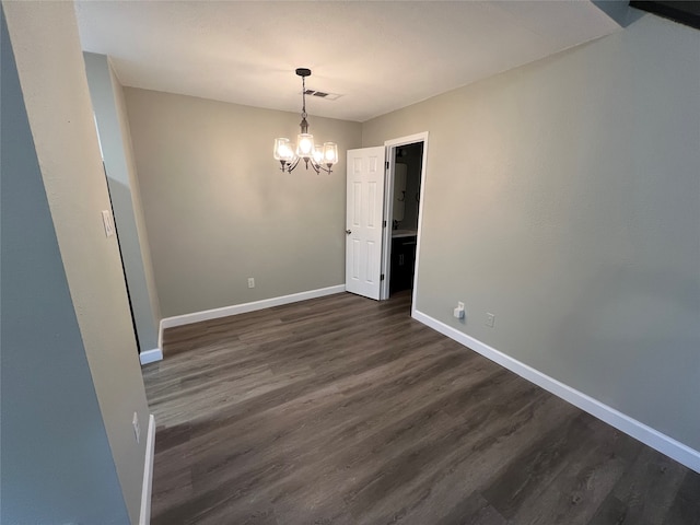 unfurnished dining area featuring a chandelier and dark wood-type flooring