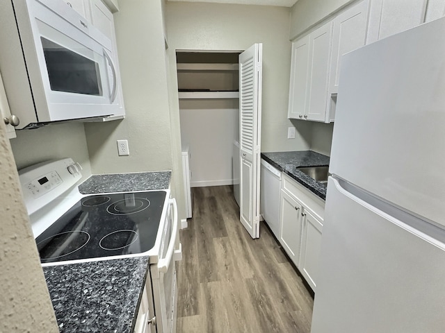 kitchen with white appliances, light hardwood / wood-style flooring, white cabinetry, and sink