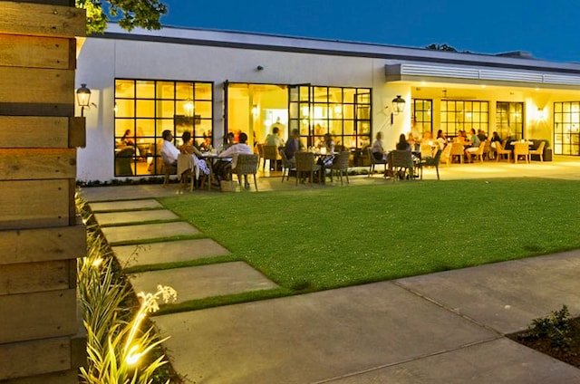 rear view of property with a lawn and a patio