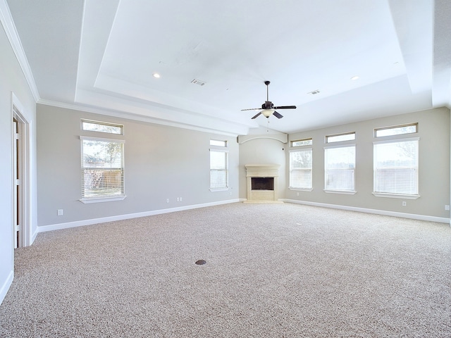 unfurnished living room featuring crown molding, carpet floors, plenty of natural light, and ceiling fan