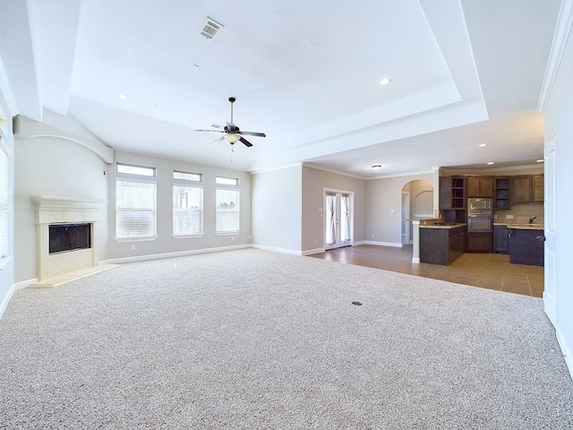 unfurnished living room featuring crown molding, carpet floors, and ceiling fan