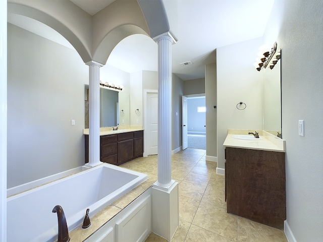 bathroom with vanity, tile patterned flooring, a bathtub, and decorative columns