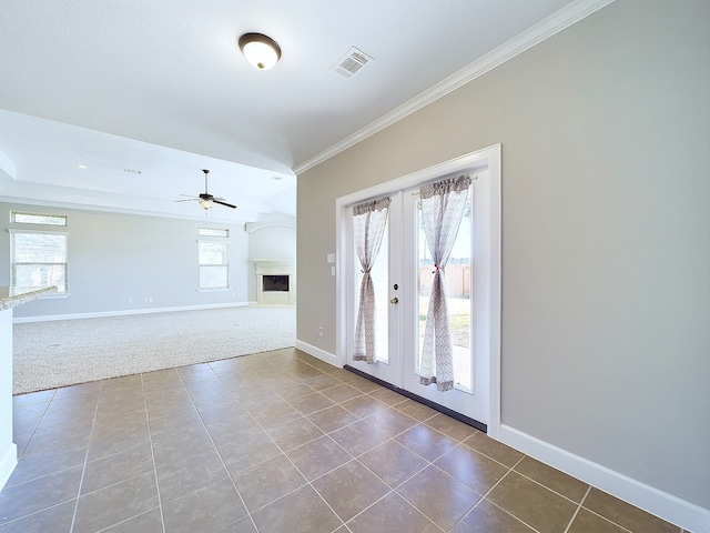 tiled spare room featuring plenty of natural light, french doors, crown molding, and ceiling fan