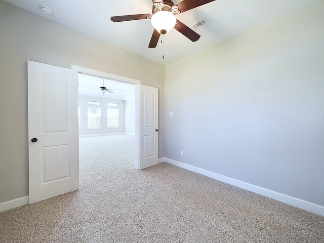 carpeted spare room featuring ceiling fan