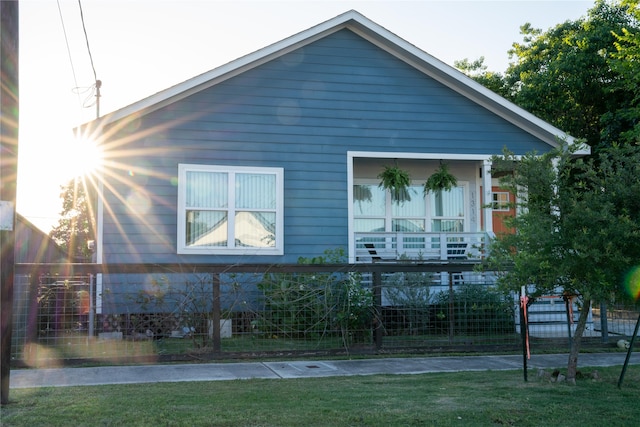 view of side of home featuring a balcony and a lawn