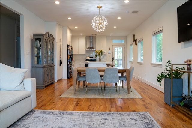 dining area featuring a notable chandelier and light hardwood / wood-style floors