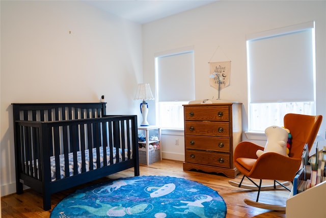 bedroom featuring light hardwood / wood-style floors and a crib