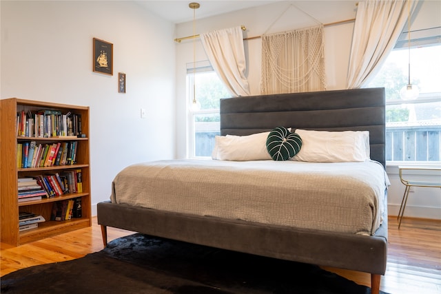 bedroom with multiple windows and wood-type flooring