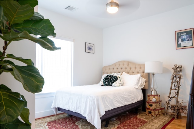 bedroom featuring multiple windows, ceiling fan, and wood-type flooring